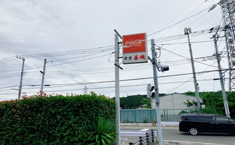 コカコーラの看板と善磯食堂の標識がある道路の写真