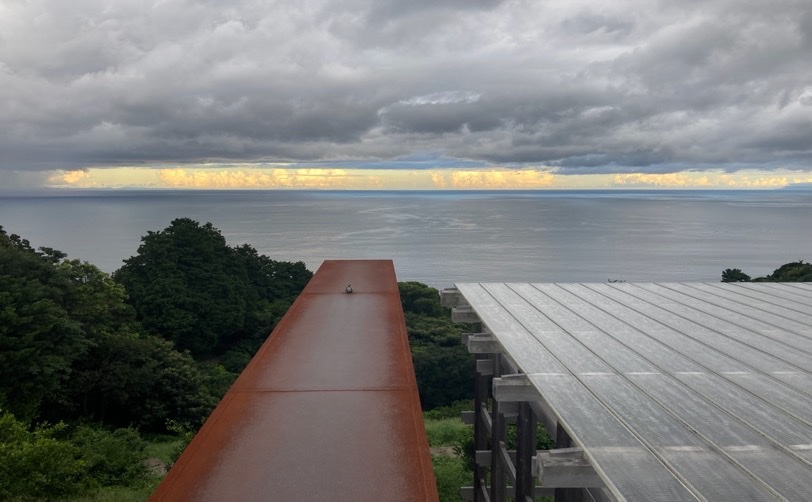海と空が見える場所の風景 木製の橋のようなものと鉄製の板がある