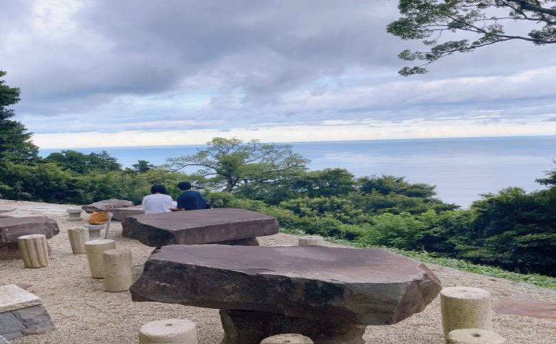 海を眺める2人の人 石の椅子