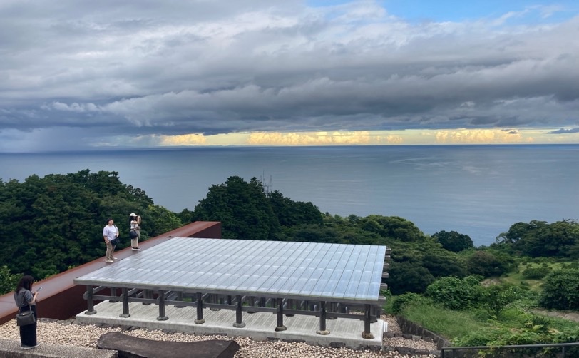 海を見下ろす展望台で写真を撮る人たち 曇り空