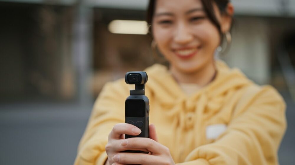 笑顔の女性が小型カメラを持っている様子