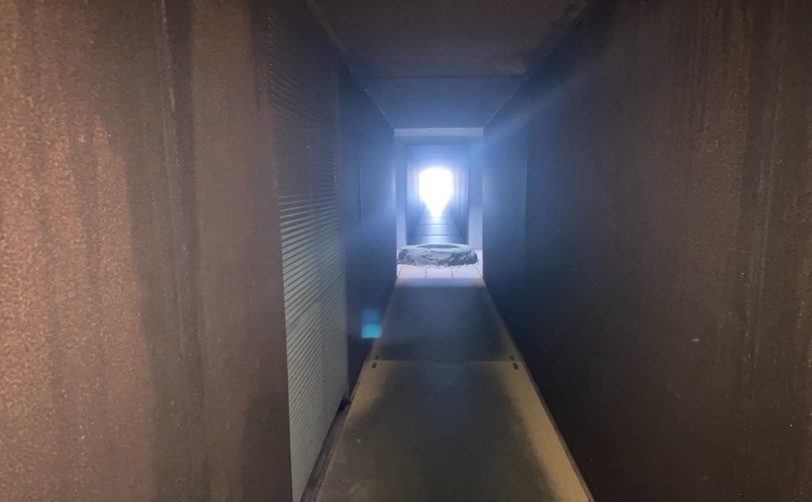 暗い通路の先に光が見える写真