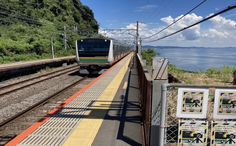 海が見える駅のホームに停車中の電車