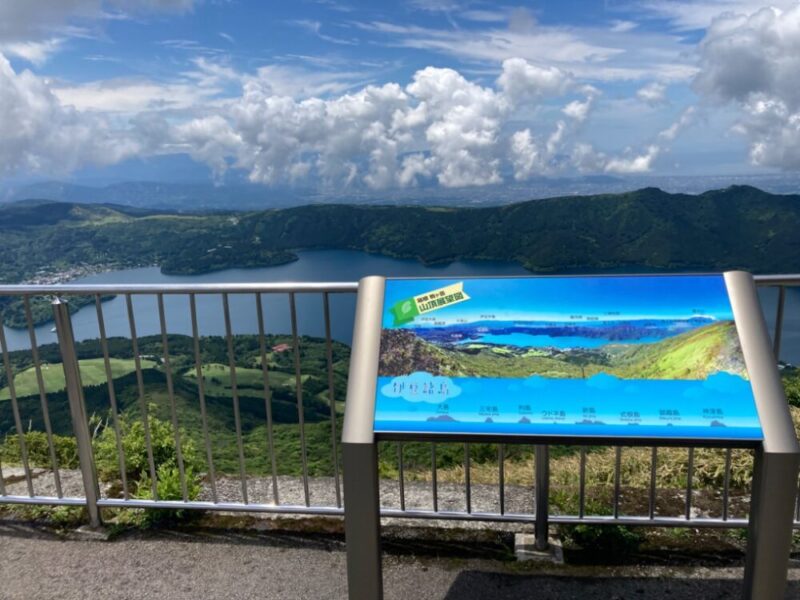展望台から見える湖と山々 広がる青空に白い雲 案内板には山湖展望図と神仙峡の文字