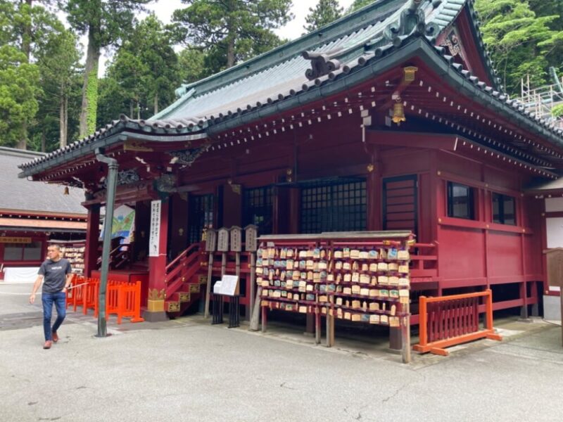 赤い色の建物とたくさんの木の札がある神社