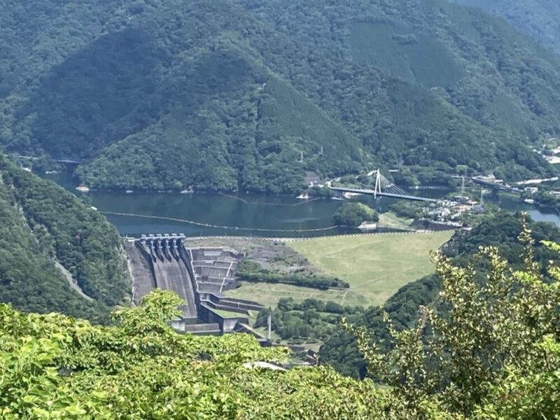 大きなダムと橋がかかる川と緑豊かな山々