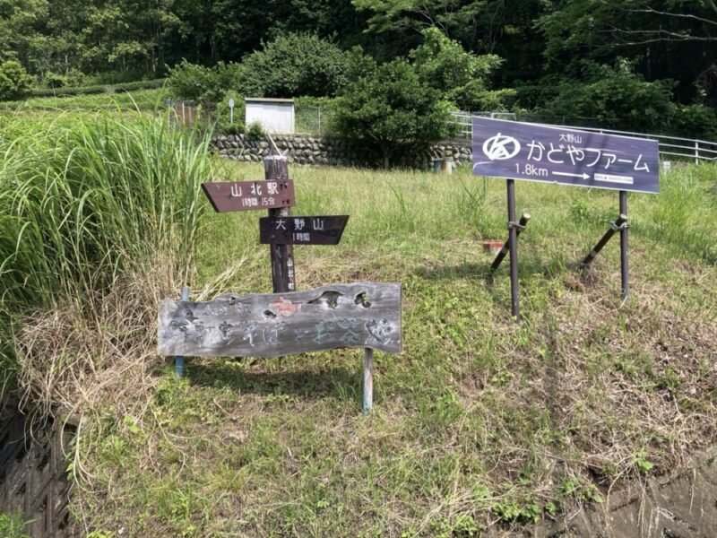 山北駅まで15分大野山まで1時間と書かれた案内標識と、大野山かどやファーム1.8キロメートルと書かれた案内標識