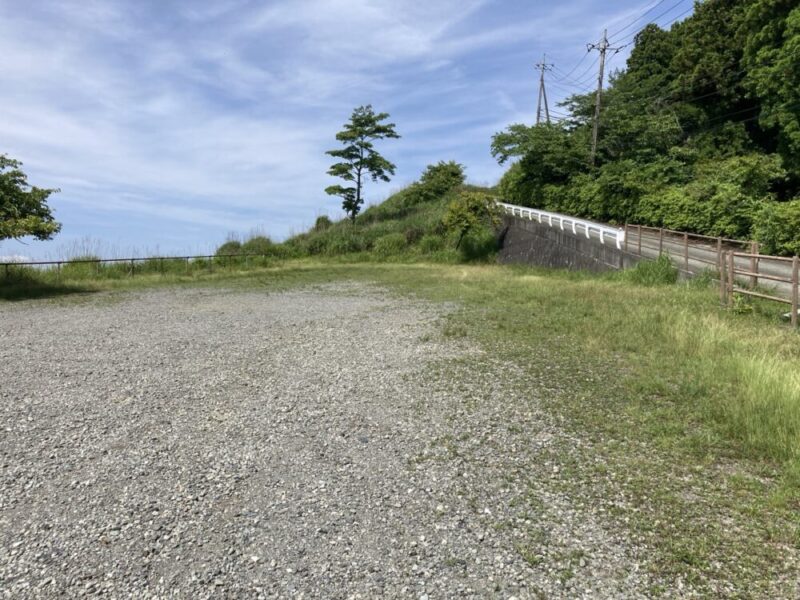 山に向かう道と空が見える、砂利敷きの広場
