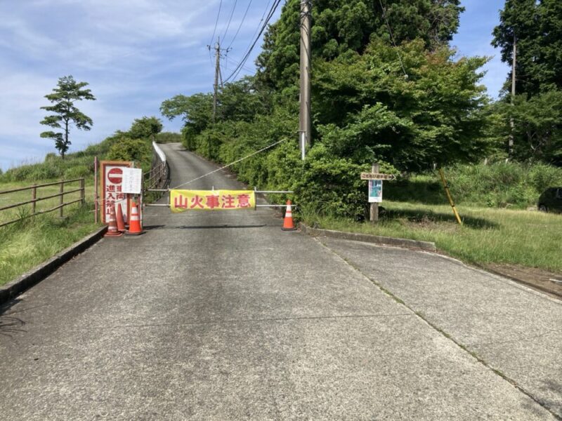 山火事注意の看板がかかった、入山禁止の封鎖された坂道