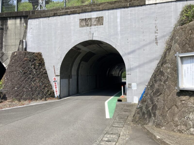 アーチ型のトンネルの入り口に車両進入禁止の標識と案内板がある