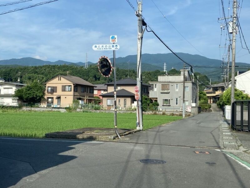 青空と田んぼのそばの道標に「森と水の公園」と書かれている景色