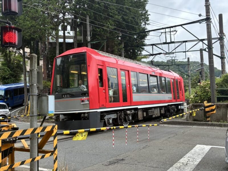 赤い電車が踏切を通過する様子