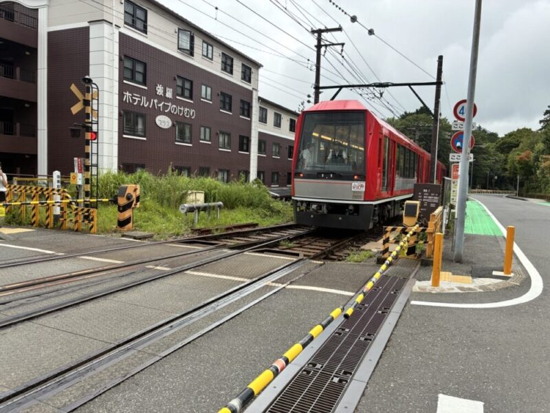 ホテルの近くの踏切を通過する赤いケーブルカー