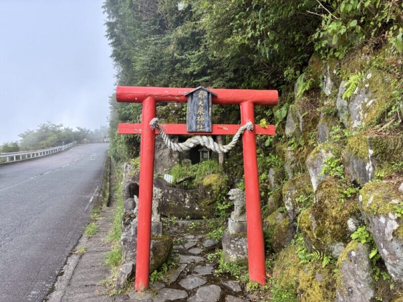 霧深い山道の脇に建つ赤い鳥居 しめ縄が飾られた氷室神社の小さな祠