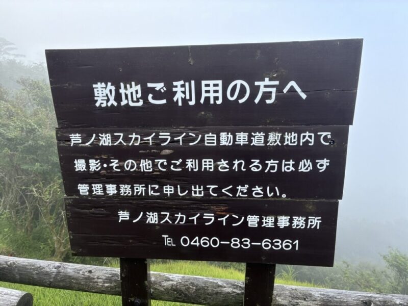 芦ノ湖スカイラインの敷地内で写真撮影などの利用時に管理事務所へ連絡が必要と書かれた木製の案内板