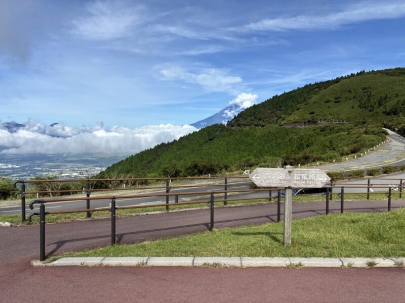 高台から富士山と雲海を望む景色 くねくねした道路沿いに芦ノ湖長尾峠の案内板がある