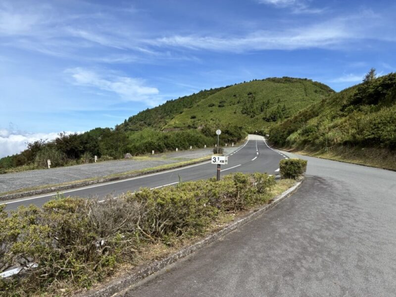 雲海と青空の山道 3.1キロメートル標識と駐車場