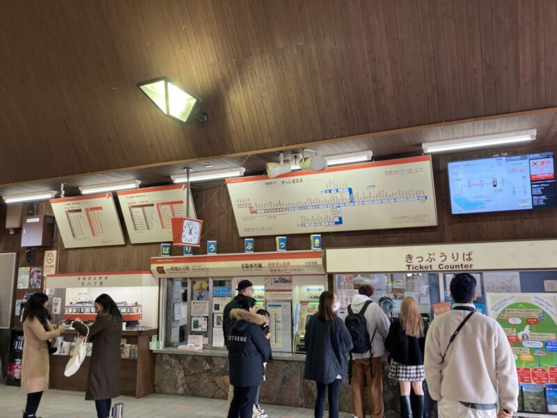 駅のきっぷ売り場で順番を待つ人々