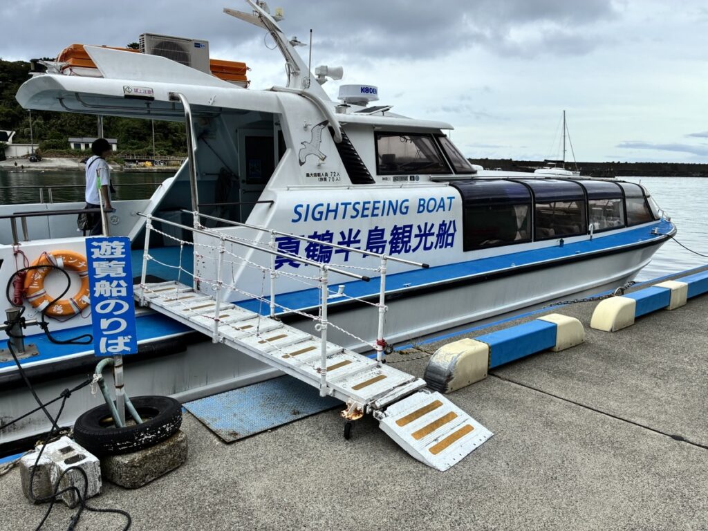 真鍋島観光船という白と青の遊覧船が遊覧船のりばの桟橋に停泊している