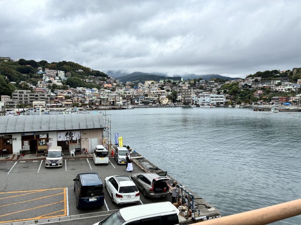 お食事処伝がある港町の駐車場と海対岸には住宅が密集