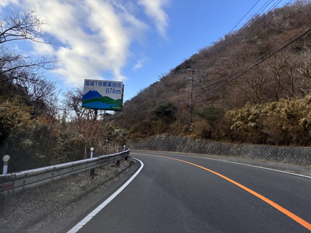 国道1号最高地点874mの標識が立つ山道のカーブ