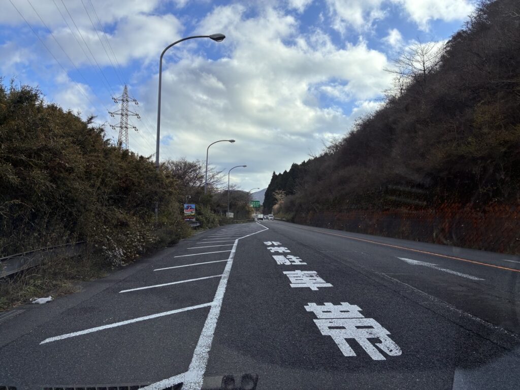 非常駐車帯のある山道の道路と青空