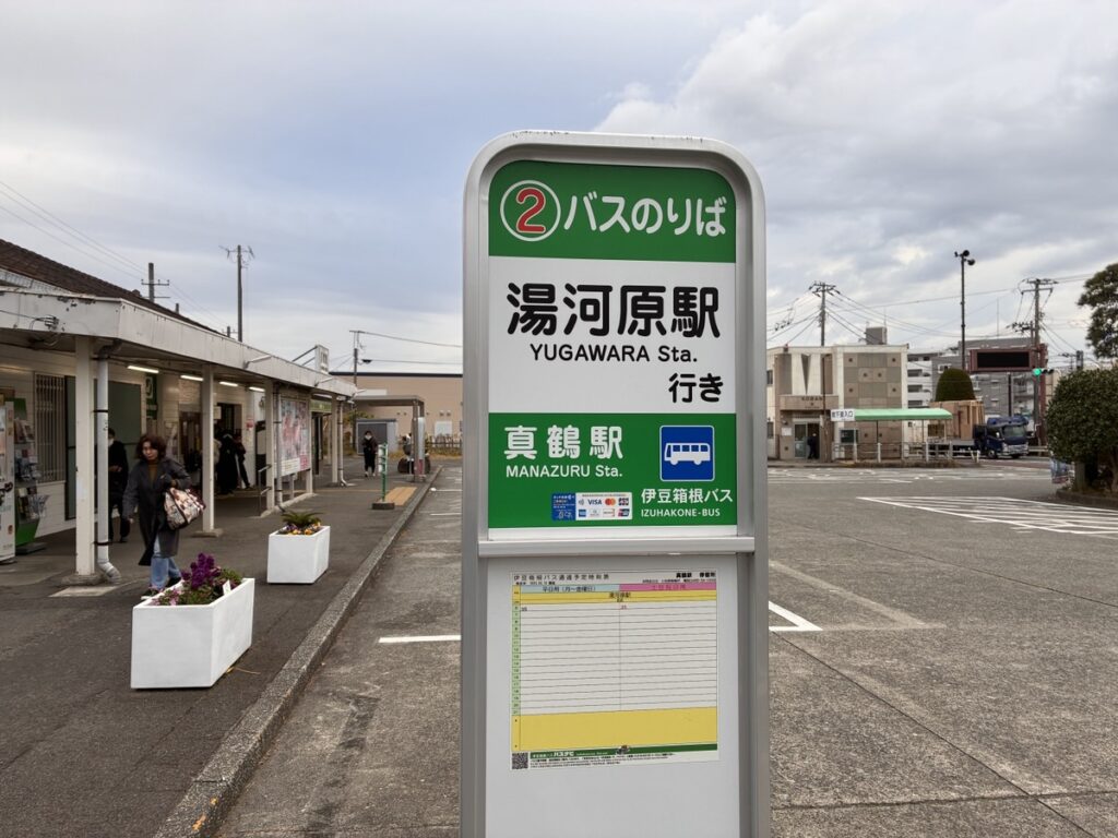 湯河原駅行きバス停標識が立つ日本の駅前広場