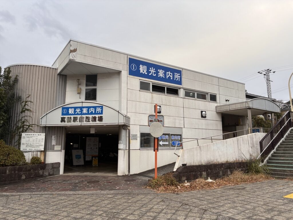 真鶴駅前の観光案内所と駐輪場がある白い建物