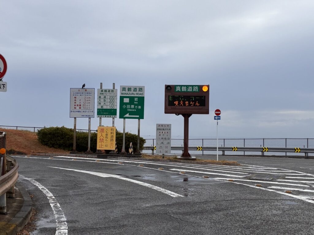 海沿いの真鶴道路にある進入禁止の道路標識と電光掲示板